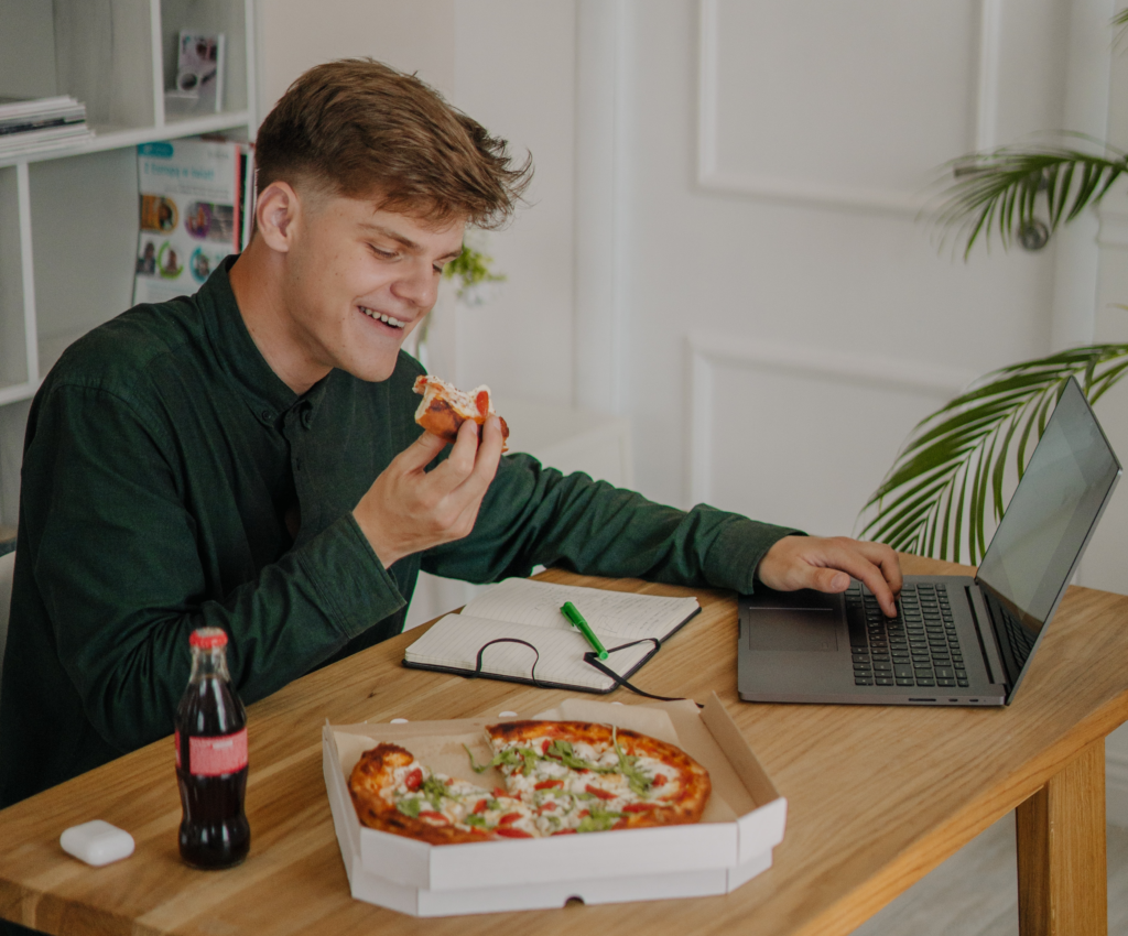 仕事中にピザを食べる男性